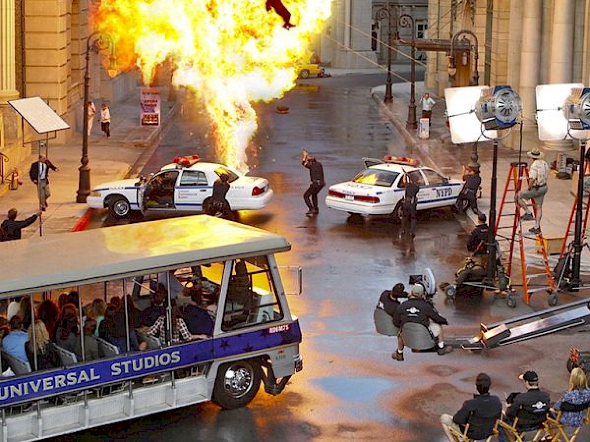 A film set displaying an action scene with an explosion, police cars, and a bus labeled 