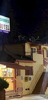 A neon-lit motel at night with a visible sign reading 